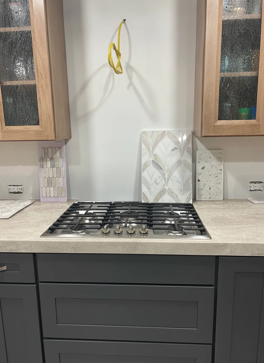 The same kitchen with lower cabinets painted charcoal and upper glass-front cabinets left in natural oak